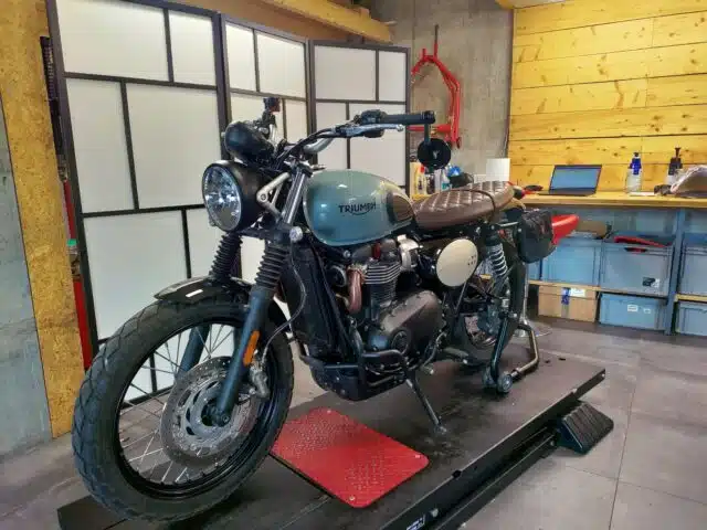 Triumph Street Scrambler en attente de réparation sur le lift Dream Moto